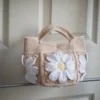 crochet daisy mini tote bag in beige on a rack