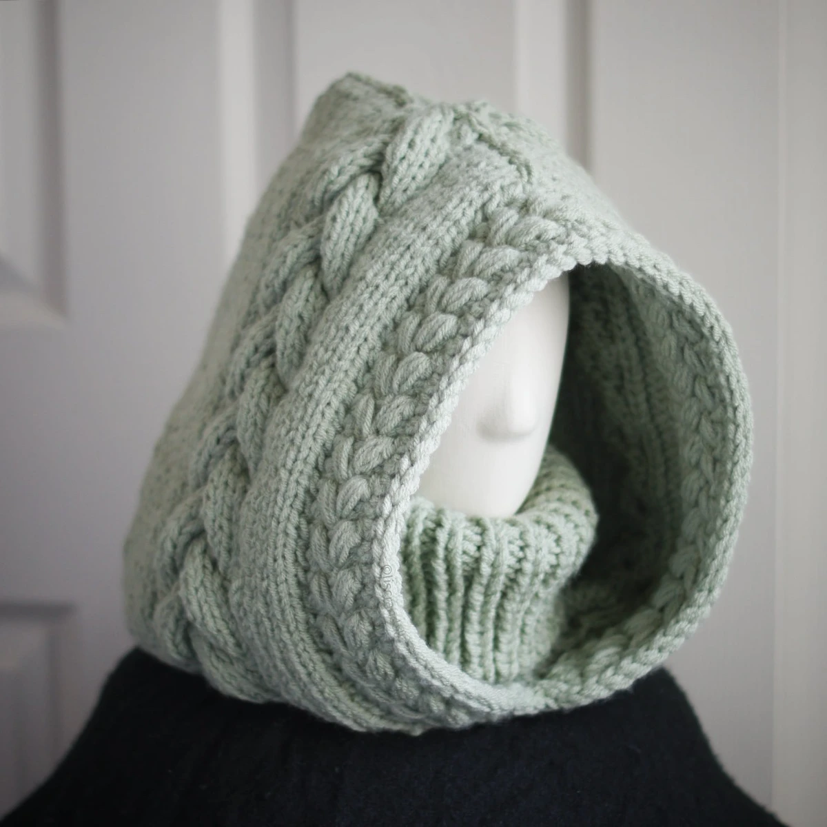 Sage green knit balaclava worn by mannequin, side view