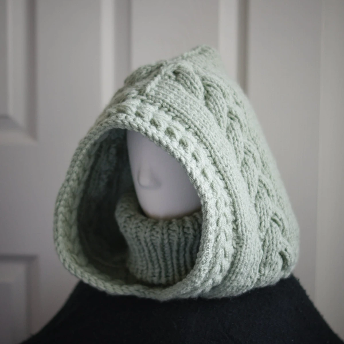 Sage green knit balaclava worn by mannequin, side view