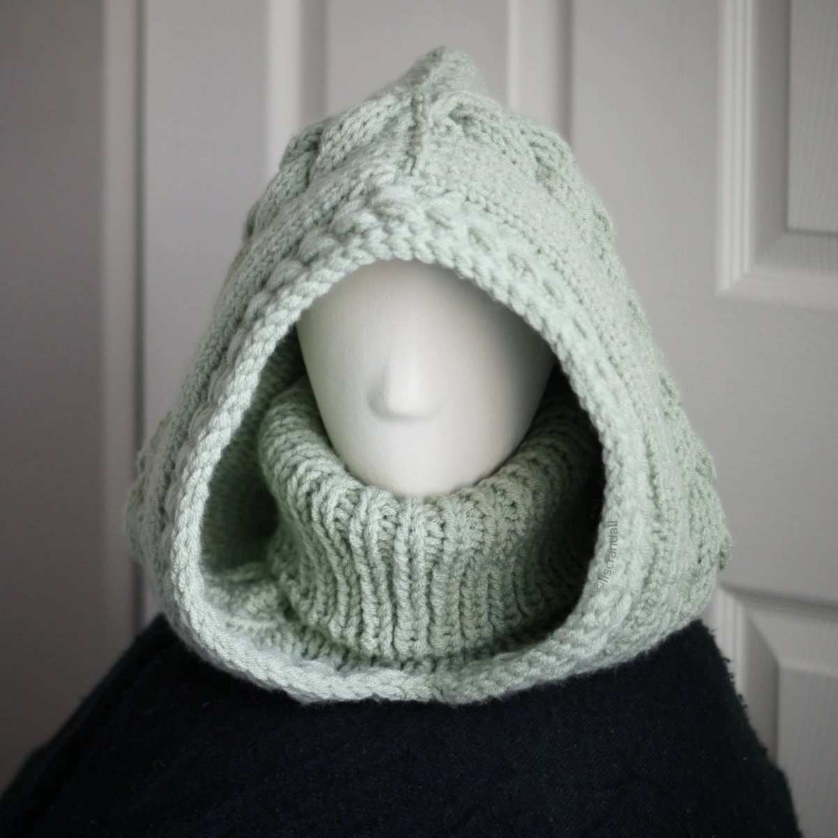 Sage green knit balaclava worn by mannequin, front view
