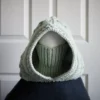 Sage green knit balaclava worn by mannequin, side view with turtleneck rolled up to cover face