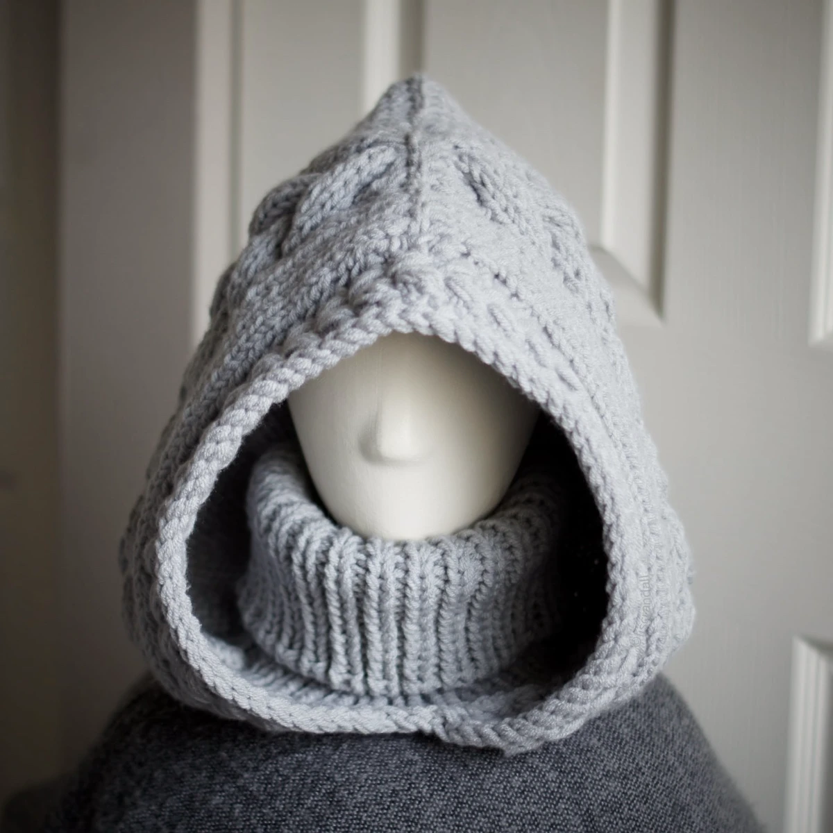 Handmade knitted balaclava in light grey with cable details and wheat stitch edging, front view with turtle neck