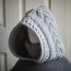 Handmade knit balaclava in light grey with cable details and wheat stitch edging, side view showing cable details
