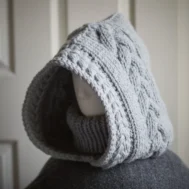 Handmade knit balaclava in light grey with cable details and wheat stitch edging, side view showing cable details