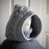 Handmade knitted balaclava in light grey with cable details and wheat stitch edging, side view showing cable details