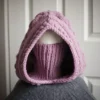 Chunky knit balaclava in mauve with cable details and wheat stitch edging, front view with face covering with turtleneck piece