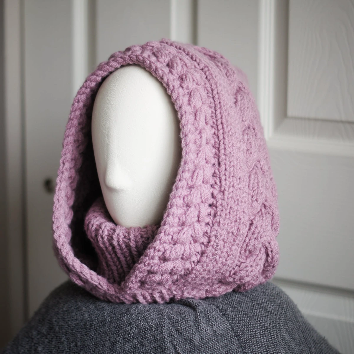 Chunky knit balaclava in mauve with cable details and wheat stitch edging, side view with cable details and different styling