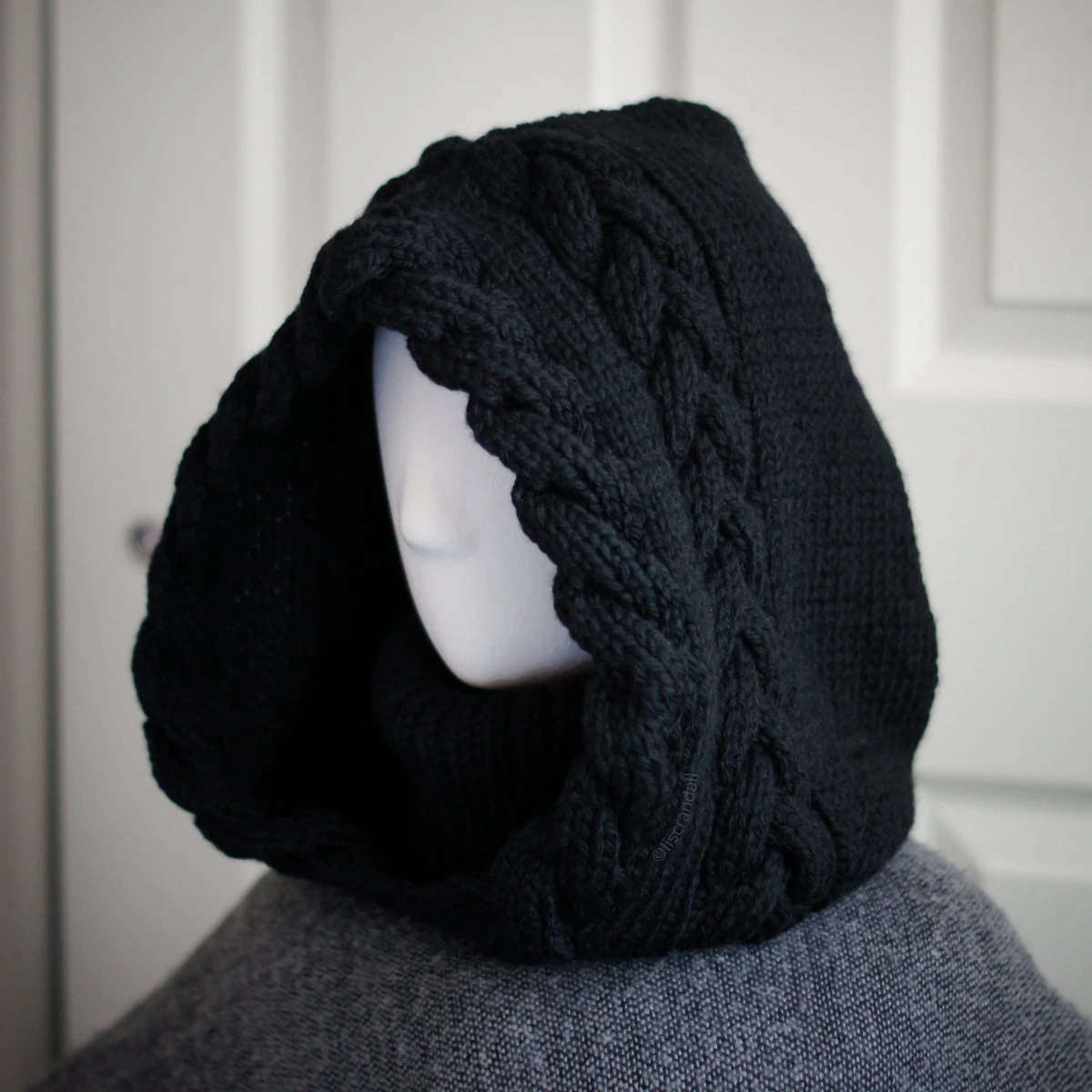 Black merino knit balaclava hood with twist edging and folded turtleneck worn by mannequin, side view