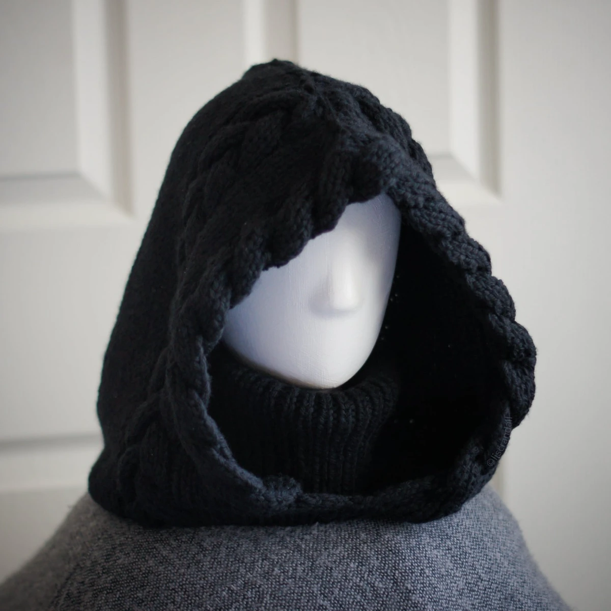 Black merino knit balaclava hood with twist edging and folded turtleneck worn by mannequin, side view