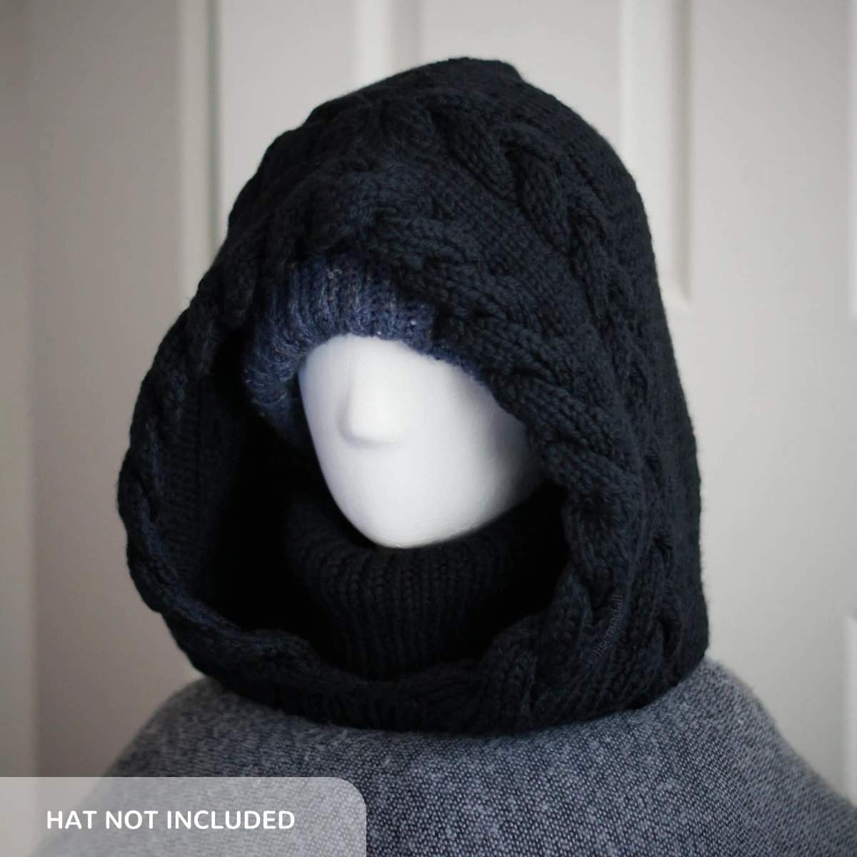 Black merino knit balaclava hood with twist edging and folded turtleneck worn by mannequin, style with a beanie under the hood