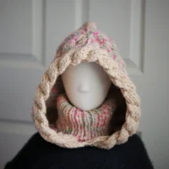 Oatmeal sprinkles knit balaclava hood with twist edging and folded turtleneck worn by mannequin