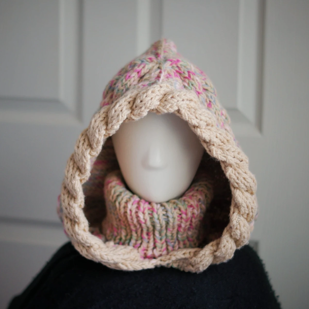 Oatmeal sprinkles knit balaclava hood with twist edging and folded turtleneck worn by mannequin