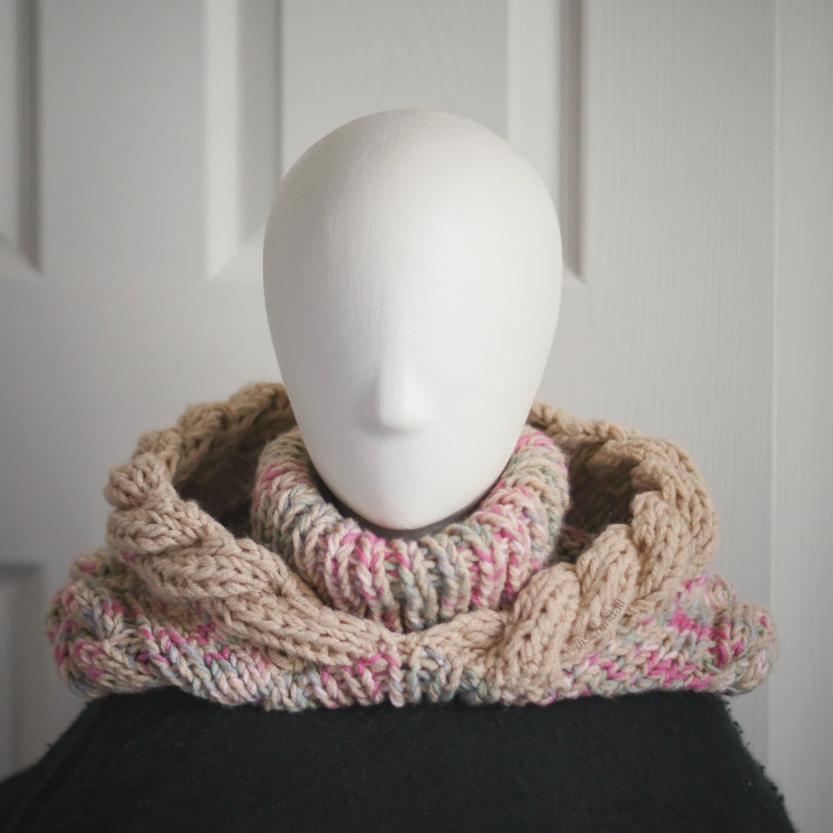 Oatmeal sprinkles knit balaclava hood with twist edging and turtleneck, with the hood dropped down on mannequin's head